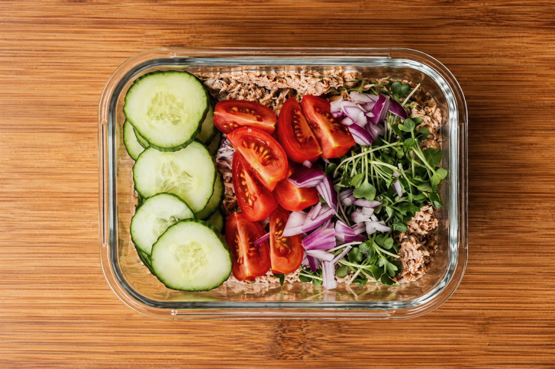 Meal-Prep-Box mit Gurke, Tomaten, Sprossen und proteinreicher Basis