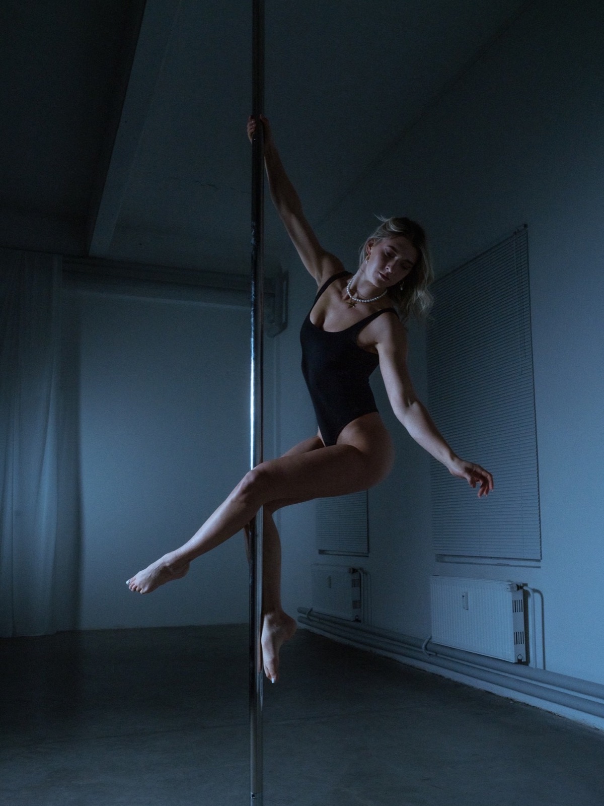 Angie an der Pole im blauen Licht